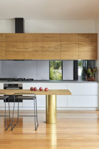 Beautiful Beam Wood Natural Lignapal timber veneer in the upper kitchen cabinets and kitchen island of Pomegranate House